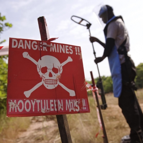 Ein großes rotes Schild im Vordergrund zeigt einen Totenkopf und die Aufschrift